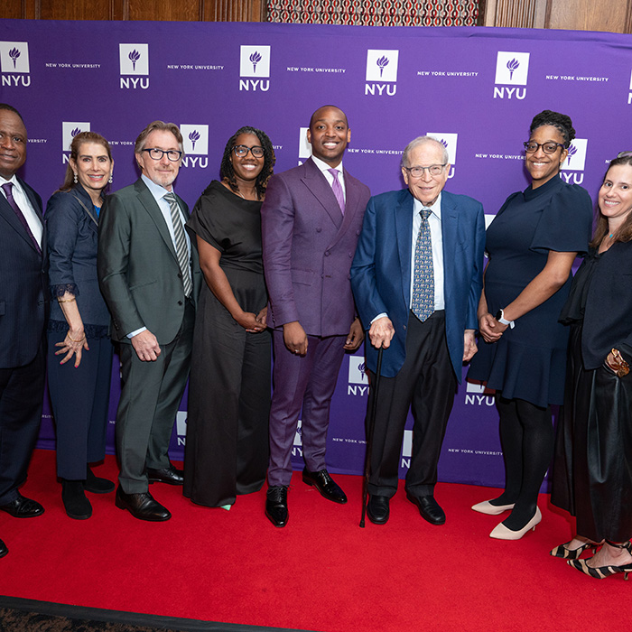 2024 Distinguished Alumni awardees taking a photo in front of NYU Alumni banner