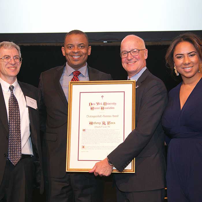 Group of nicely dress people posing with an award