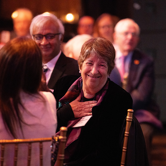 Woman at table smiling during 2024 Alumni Awards event