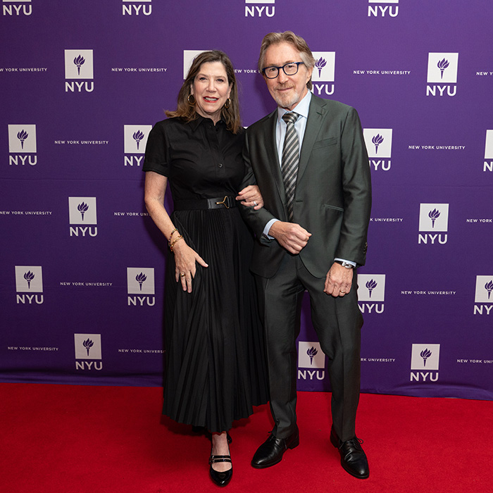 Don Katz and wife standing in front of NYUAA Awards banner