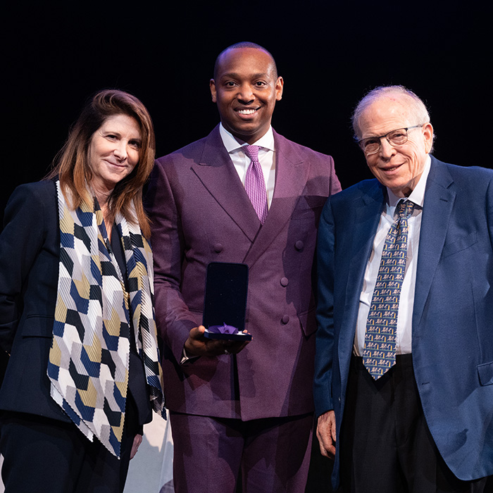 William Berkley recieving award on stage from a male and female