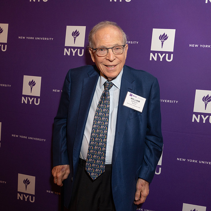 William Berkley standing in front of NYUAA Awards banner